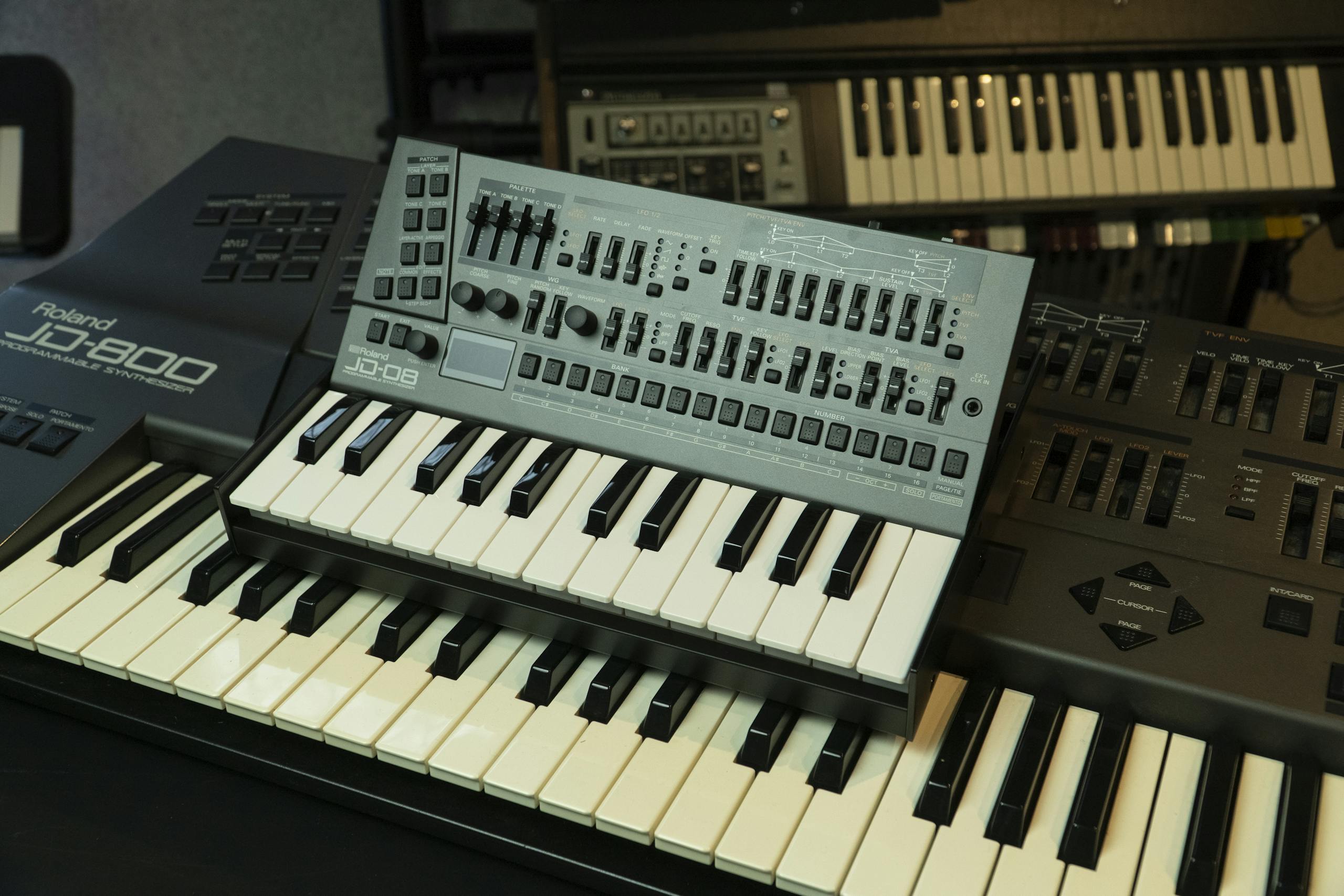 Close-up of Roland synthesizers in a professional music production setup.