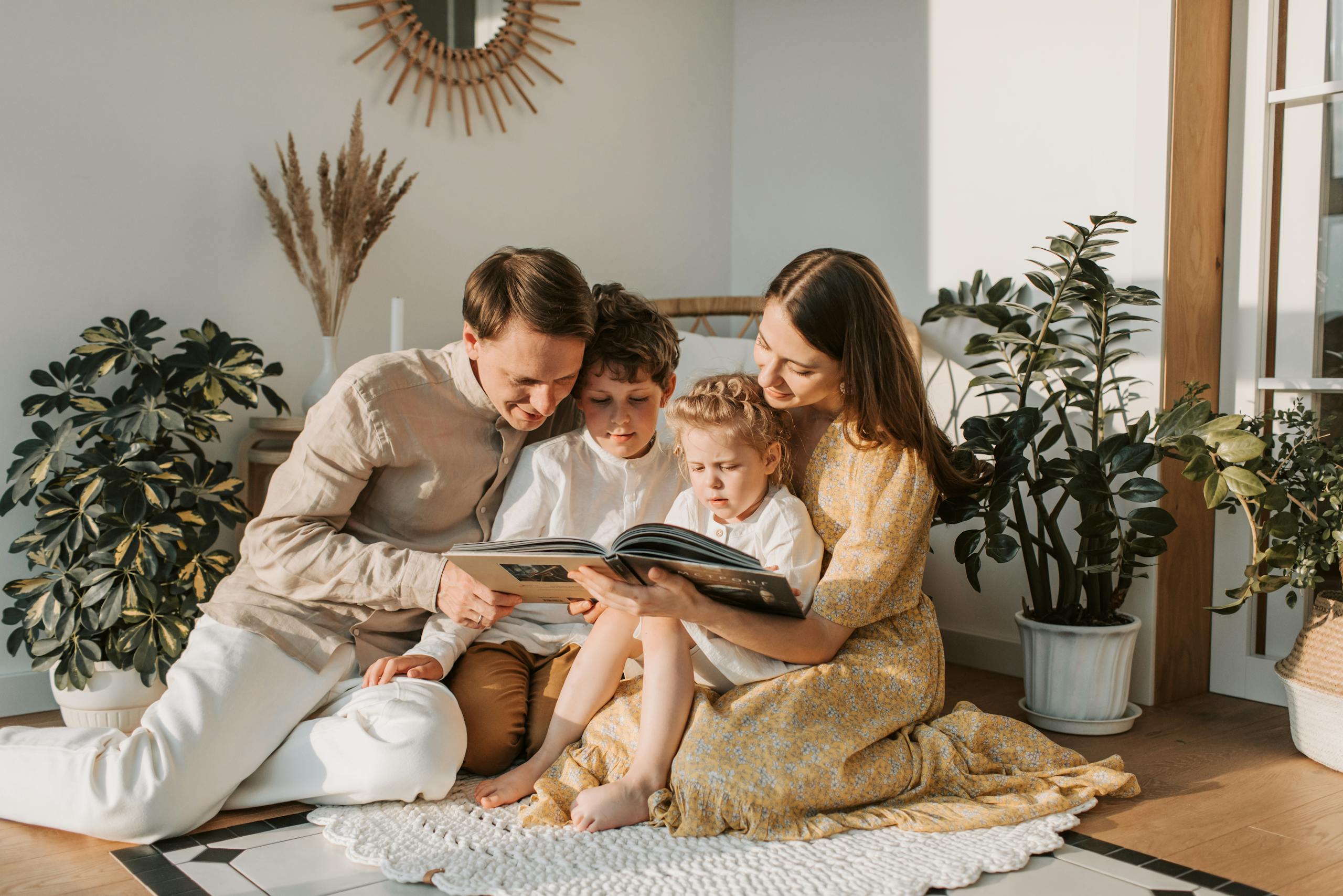A joyful family shares a book indoors, surrounded by houseplants, promoting reading and togetherness.
