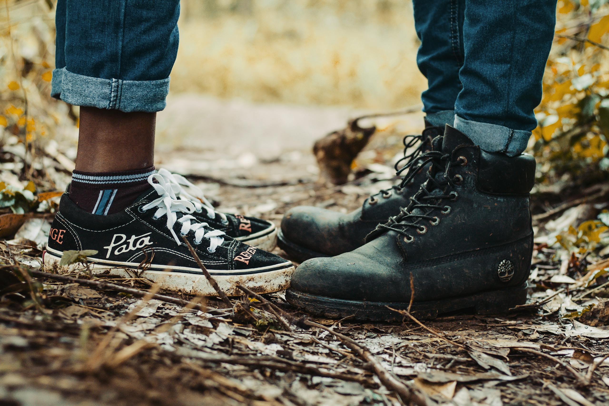 Photo by Nicholas Githiri Close-up of diverse footwear on a wooded path symbolizing unity and adventure.